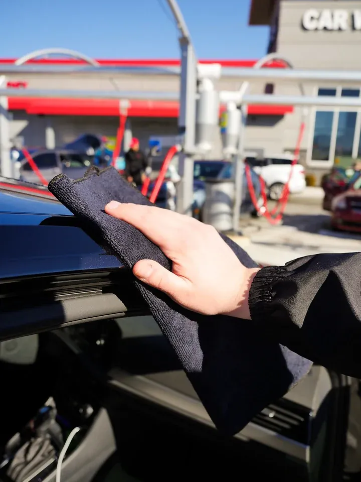 A customer hand-drying his car with a free Soapify towel