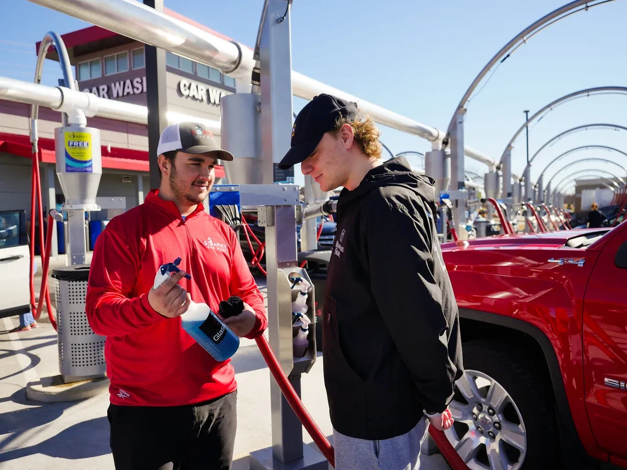 A Soapify team member handing a customer free glass cleaner