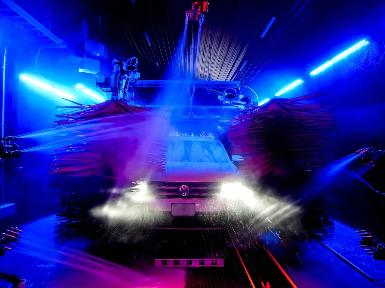 A car lit up inside Soapify's neon wash tunnel